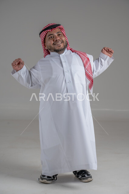 Social empowerment of people with disabilities, portrait of a short Saudi Arabian Gulf young man wearing traditional thobe and shemagh moving his hands in gestures indicating waking up from sleep, full body image, gray background