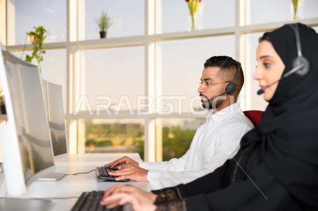 موظفان عربيان خليجيان سعوديان يعملان في خدمة العملاء، موظف وموظفة يرتديان سماعة الاتصال، استعلامات واستفسارات، الاجابه على اسئلة العملاء، اجراء اتصال فيديو من خلال الحاسوب، متابعة وتطوير العمل