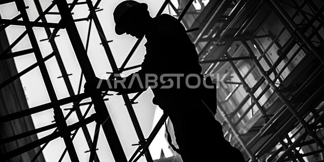 الاشراف على سير العمل بشكل مباشر، نمو القطاع الهندسي بالمملكة العربية السعودية، صورة ظلية لمهندس عربي خليجي سعودي يرتدي سترة وخوذة الحماية يعمل في مبنى تحت التشييد، أعمال البناء والمقاولات والتطوير المعماري، الهياكل والأساسات للمباني والمشاريع السكنية، سالوليت