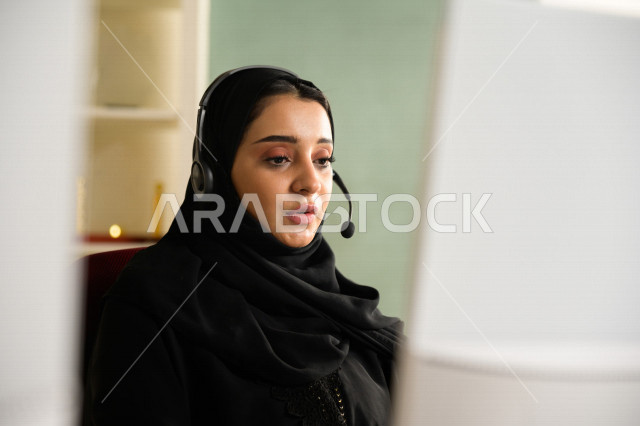 A Saudi Arabian Gulf employee working in customer service and wearing a headset, inquiries and inquiries, answering customer questions, making video calls through a computer, following up and developing work