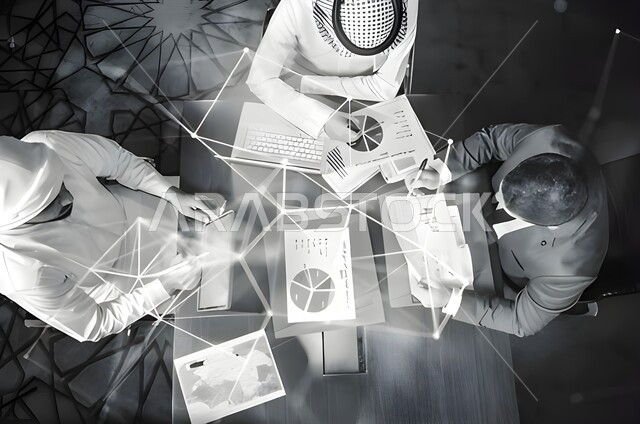 مناقشة الرسم البياني المالي، استشارات مالية ومحاسبية، استخدام الحاسوب المحمول في تدوين الملاحظات، دمج التقنية الحديثة بالعمل، مفهوم الخطط الاستثمارية، تحقيق اهداف العمل، صورة من الاعلى لمجموعة من الموظفين في اجتماع عمل