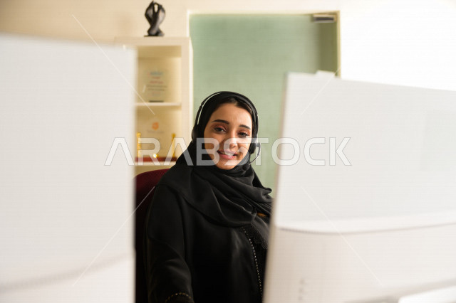 موظفة عربية خليجية سعودية تعمل في خدمة العملاء وترتدي سماعة الاتصال، استعلامات واستفسارات، الاجابه على اسئلة العملاء، اجراء اتصال فيديو من خلال الحاسوب، متابعة وتطوير العمل