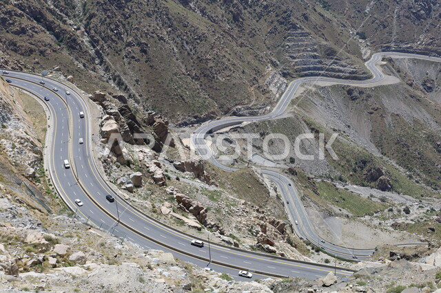 الطبيعة والبيئة الجبلية والقمم والمرتفعات، حركة مرور وسير السيارات على جبال الهدا في مدينة الطائف، صورة جوية لطريق إسفلتي ملتوي وعر وسط الجبال الصخرية في منطقة عقبة الهدا، أماكن سياحية مشهورة في المملكة العربية السعودية