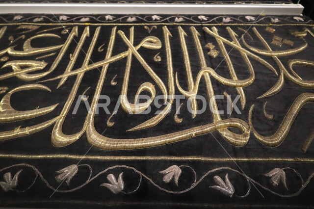 عرض لكسوة الكعبة المطرزة بخيوط ذهبية وفضية، المخطوطات الدينية الأثرية التاريخية، صورة مقربة للستارة الحريرية السوداء لباب الكعبة المنقوشة بآيات القرآن الكريم، التعرف على ثقافة وتاريخ الأرض المقدسة، متحف بينالي للفنون الإسلامية في جدة بالمملكة العربية السعودية