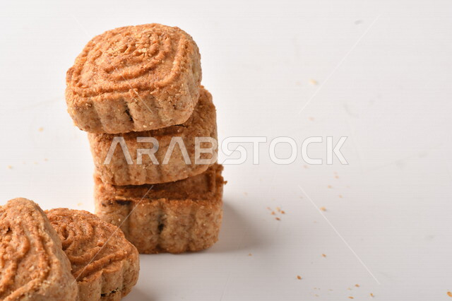 معمول محشو بالتمر ، مربع الشكل من الحلويات الشعبية الهشة اللذيذة على خلفية بيضاء ، صورة لكعك العيد الشهي محشو بالتمر ، حلويات شعبية طازجة