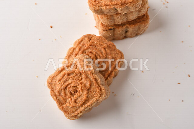 معمول محشو بالتمر ، مربع الشكل من الحلويات الشعبية الهشة اللذيذة على خلفية بيضاء ، صورة لكعك العيد الشهي محشو بالتمر ، حلويات شعبية طازجة