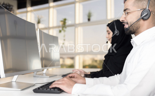 موظفان عربيان خليجيان سعوديان يعملان في خدمة العملاء، موظف وموظفة يرتديان سماعة الاتصال، استعلامات واستفسارات، الاجابه على اسئلة العملاء، اجراء اتصال فيديو من خلال الحاسوب، متابعة وتطوير العمل