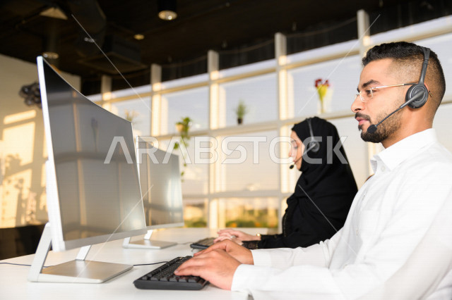 موظفان عربيان خليجيان سعوديان يعملان في خدمة العملاء، موظف وموظفة يرتديان سماعة الاتصال، استعلامات واستفسارات، الاجابه على اسئلة العملاء، اجراء اتصال فيديو من خلال الحاسوب، متابعة وتطوير العمل