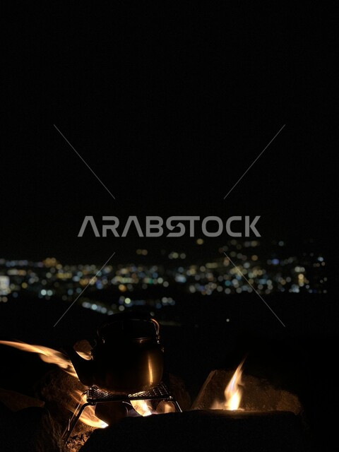 موقد نار مشتعل في احدى الرحلات البرية في صحراء المملكة  في وقت الليل، اجواء التخييم الممتعة في المناطق الصحراوية السياحية، مرتفعات وتشكلات مدينة ابها في مدينة الرياض بالسعودية 