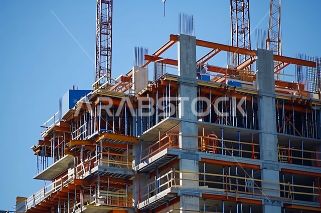Concept of structural and architectural engineering, construction cranes, concrete pouring and foundation laying, implementation of construction plan and metal structure formation, modern building under construction, urban expansion in the Kingdom of Saudi Arabia