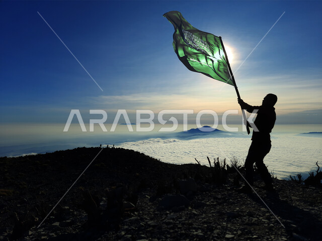 الاحتفال بذكرى اليوم الوطني السعودي 23 سبتمبر, يوم العلم 11 مارس, إظهار مشاعرالحب والولاء للوطن والانتماء اليه, صورة ظلية لشاب عربي خليجي سعودي يحمل بيده علم المملكة ويرفع عاليا, أعياد ومناسبات وطنية سالوييت