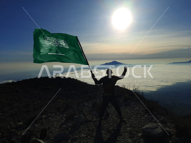 الاحتفال بذكرى اليوم الوطني السعودي 23 سبتمبر, يوم العلم 11 مارس, إظهار مشاعرالحب والولاء للوطن والانتماء اليه, صورة ظلية لشاب عربي خليجي سعودي يحمل بيده علم المملكة ويرفع عاليا, أعياد ومناسبات وطنية سالوييت