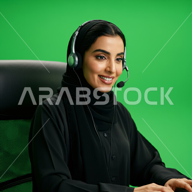 ارتداء سماعة الاتصال للإجابة عن الاستعلامات والاستفسارات، زيادة مستوى رضا العميل، استخدام التقنيات الحديثة، بورتريه مقرب لسيدة عربية سعودية خليجية ترتدي الحجاب والعباءة تعمل في الدعم الفني وخدمة العملاء، خلفية خضراء، كروما