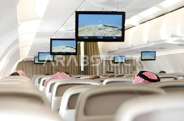 مفهوم السياحة والسفر، الركاب داخل طائرة حديثة مجهزة بشاشات في احد المطارات الدولية، شركات و خطوط الطيران السعودي، وسائل النقل والمواصلات الجوية، توفير الخدمات المتطورة لسهولة التنقل بين البلدان في المملكة العربية السعودية