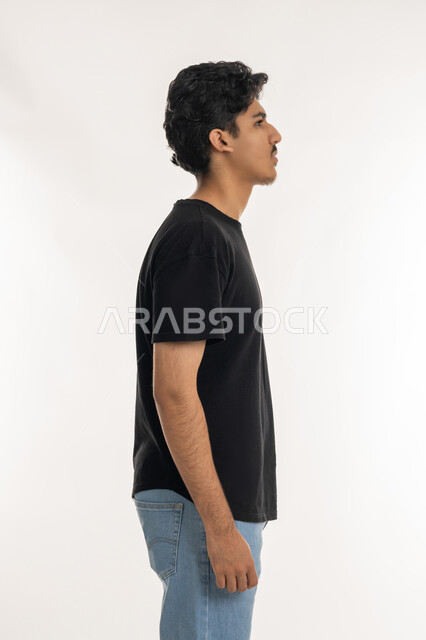 الاهتمام بالأناقة والمظهر الخارجي، الوقوف باستقامة وثبات، مفهوم الرجولة العربية, النظر الى شيء ما بإيماءات الجدية، بورتريه من الجانب لشاب عربي خليجي إماراتي يرتدي الزي الكاجوال يركز في مكان محدد, خلفية بيضاء