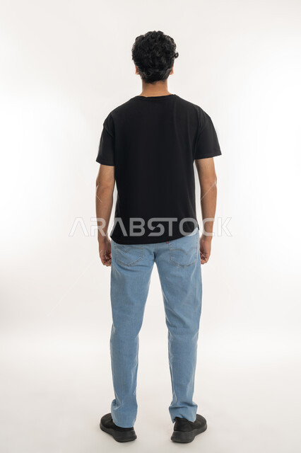 الأناقة والرجولة والشياكة، الاهتمام بالمظهر الخارجي، الوقوف باستقامة وثبات، بورتريه من الخلف لشاب عربي خليجي إماراتي يرتدي الزي الكاجوال، الطول الكامل للجسم، خلفية بيضاء