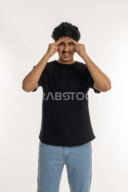 Feeling headache and dizziness, Need for treatment and rest, Migraine and migraine pain, Gestures of pain, fatigue and illness, Portrait of a young Arab Gulf Emirati man wearing casual clothes putting his hands on his head feeling dizzy, Feeling headache and dizziness, White background