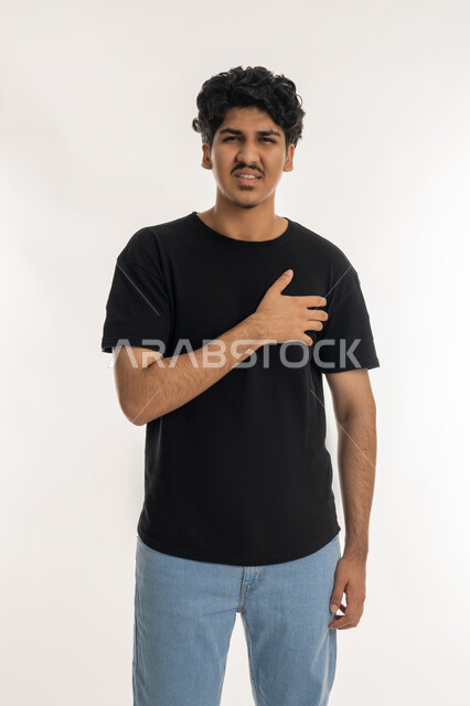 التعب والإرهاق والضغوطات النفسية, ضرورة الذهاب للطبيب لتلقي العلاج المناسب، الاحساس بذبحه صدريه، بورتريه لشاب عربي خليجي إماراتي يرتدي الزي الكاجوال يضع يده على صدره، الشعور بحالة سيئة من الوخز والألم, اضطرابات وأمراض قلبية, خلفية بيضاء