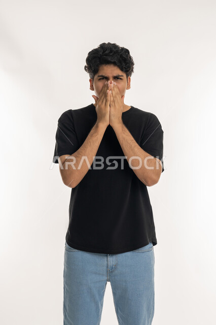 التهاب الأنف و الجيوب التحسسية, الشعور بالمرض و الزكام, الحاجة إلى العلاج والدواء, بورتريه لشاب مراهق عربي خليجي إماراتي يرتدي الزي الكاجوال يضع يديه على وجهه بإيماءات العطاس, خلفية بيضاء