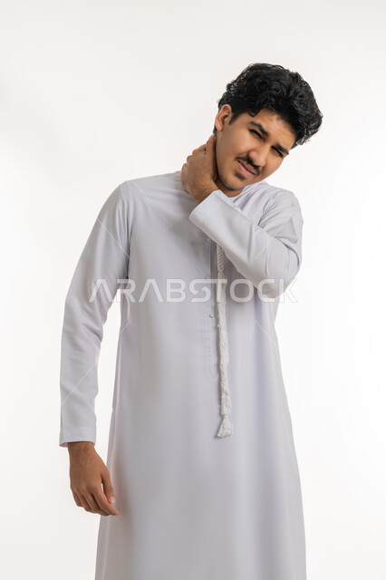 آلام العنق والعمود الفقري, الحاجة للعلاج الفيزيائي، الإحساس بالتعب والإرهاق, وجع مفاصل و عظام الرقبة, بورتريه لشاب مراهق عربي خليجي إماراتي يرتدي الكندورة يضع يده حول عنقه بإيماءات الألم, خلفية بيضاء