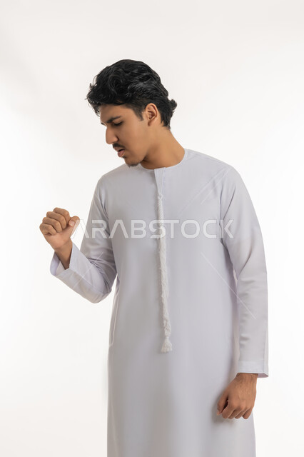 الإصابة بفايروس كورونا، الانفلونزا والتهاب الرئة, الشعور بالمرض و الكحة, الحاجة إلى زيارة الطبيب و العلاج, بورتريه لشاب مراهق عربي خليجي إماراتي يرتدي الكندورة يرفع يده إلى فمه بإيماءات السعال, خلفية بيضاء