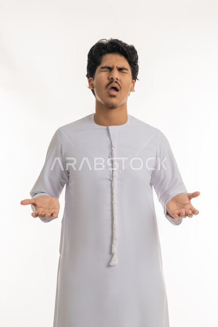 الاستفسار و التساؤل عن شيء معين, تعابير الاستفهام و عدم الفهم و الحيرة, بورتريه لشاب مراهق عربي خليجي إماراتي يرتدي الكندورة يشير بيديه بإيماءات الاستغراب و التعجب, خلفية بيضاء