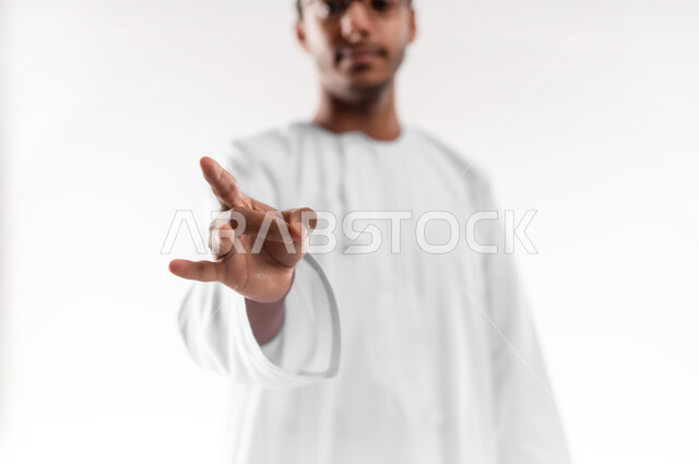 التواصل مع ذوي الهمم سمعيا أو صوتيا، تعليم لغات الإشارة للصم والبكم، الاهتمام بالأناقة والمظهر الخارجي، بورتريه مقرب لشاب عربي خليجي عماني يرتدي الدشداشة والكمه والنظارة الطبية ينظر الى الكاميرا يرفع يده بدلالة الرقم ثمانية، خلفية بيضاء