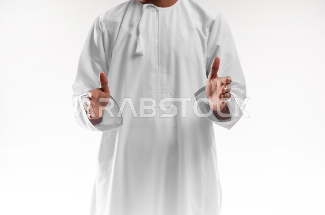 Trying to estimate the size of things, holding and containing an item, the concept of elegance and interest in external appearance, close-up portrait of a young Arab Gulf Omani man wearing a dishdasha, a sleeve and eyeglasses, opening his hands to display three-dimensional holographic elements, white background