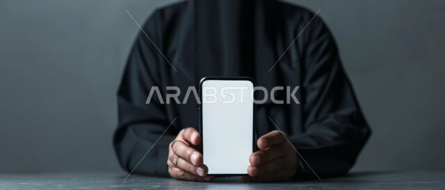استخدام أجهزة التكنولوجيا الحديثة والمتطورة، بورتريه لرجل عربي خليجي سعودي يحمل هاتف محمول, عرض شاشة بيضاء فارغة عبر الجوال, متاجر تسوق الكترونية، خلفية رمادية