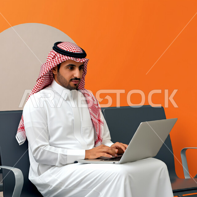 إيماءات الاندماج والتركيز أثناء العمل عبر الحاسب المحمول، الجلوس في إحدى المكاتب، استخدام الأجهزة التكنولوجية الحديثة والمتطورة، رجل عربي خليجي سعودي يرتدي الشماغ والثوب التقليدي يجلس على الكرسي يستخدم اللابتوب