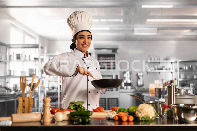 العمل في مطابخ ومطاعم المملكة، فنون ومهارات الطبخ, إعداد الاكل بمكونات طبيعية طازجة، صورة لامرأة عربية خليجية سعودية مبتسمة ترتدي مئزر الطبخ تقوم بإعداد الطعام بايماءات السرور والسعادة، فن الطهي وتحضير الأطعمة اللذيذة، تقديم المأكولات الشعبية التقليدية الشهية