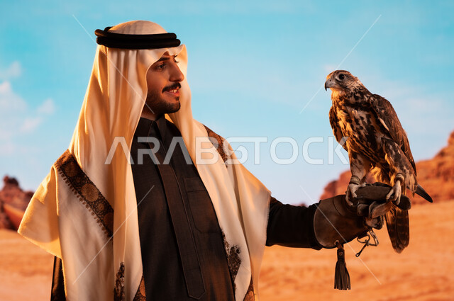 الفخر بالتراث السعودي العريق في تربية الطيور الجارحة الحرة، رمز القوة والتحدي وحدة البصر، فعاليات نادي الصقور في موسم الصيد السنوي في المملكة العربية السعودية، صورة لشاب عربي خليجي سعودي يقوم بترويض طائر الصقر في المحميات الطبيعة