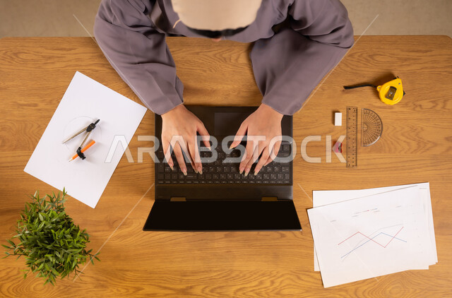 التدريب الحسابي عن طريق الاونلاين، تعلم الحساب والرياضيات من خلال المواقع الالكترونية، دمج التكنولوجيا في الحياة العلمية، استخدام التقنيات الحديثة والمتطورة، بورتريه علوي عامودي لإمرأة عربية خليجية عمانية تستخدم جهاز الحاسوب المحمول، رسم المخططات البيانية