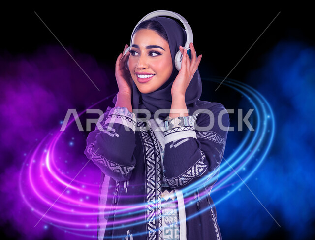 مفهوم الإصغاء والإستماع، إيماءات السعادة والاندماج، الاستمتاع في أوقات الفراغ, إستخدام تقنيات الهيدفون، صورة مقربة لسيدة عربية خليجية سعودية مبتسمة محجبة ترتدي العباءة تضع سماعات الرأس الصوتية تستمع إلى الموسيقى، خلفية ملونة