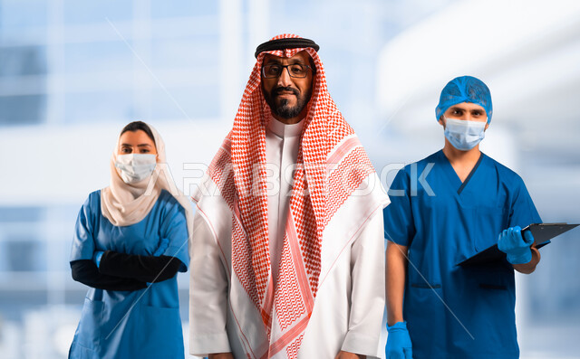 Looking at the camera with self-confident gestures, working in the health sector, a Saudi Arabian Gulf man wearing a traditional shemagh and thobe, behind him a medical staff wearing face masks, providing medical services to patients, various professions and jobs in the Kingdom of Saudi Arabia, white background