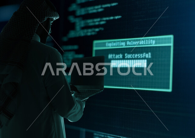 مفهوم التحول الرقمي، دمج التكنولوجيا المتطورة مع العمل، استخدام التقنيات الحديثة، صورة من الخلف لرجل أعمال عربي خليجي سعودي يرتدي الشماغ والثوب التقليدي يمسك بيده جهاز اللابتوب المحمول يقف امام شاشة إلكترونية بأيقونات هولوجرامية مضيئة، رؤية مستقبلية تكنولوجية