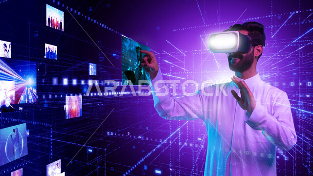 محاكاة العالم الخيالي، دمج التكنولوجيا المتطورة مع العمل، استخدام التقنيات الحديثة، صورة مقربة لشاب عربي خليجي سعودي يرتدي الثوب التقليدي ونظارات الواقع الافتراضي يقوم بالنقر على الايقونات الهولوجرامية المضيئة ثلاثية الأبعاد، مفهوم التحول الرقمي