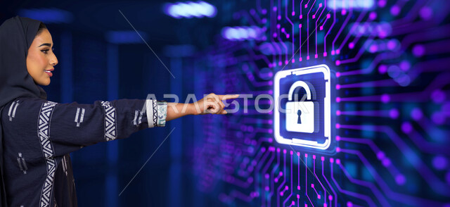 المحافظة على أمن المعلومات، استخدام التقنيات الحديثة، صورة مقربة من الجانب لسيدة عربية خليجية سعودية محجبة تشير بإصبع السبابة الى شاشة إلكترونية بأيقونات هولوجرامية لرمز القفل مضيئة، مفهوم التحول الرقمي
