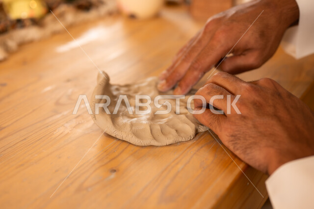 منحوتات وزخارف وأعمال فنية, ذكرى اليوم الوطني السعودي 23 سبتمبر, الصناعات التشكيلية اليدوية، شاب عربي خليجي سعودي يعمل بعجينة الفخار, حرف ومهن شعبية تراثية قديمة، تأسيس الدولة السعودية 1727 م, مناسبات واعياد وطنية