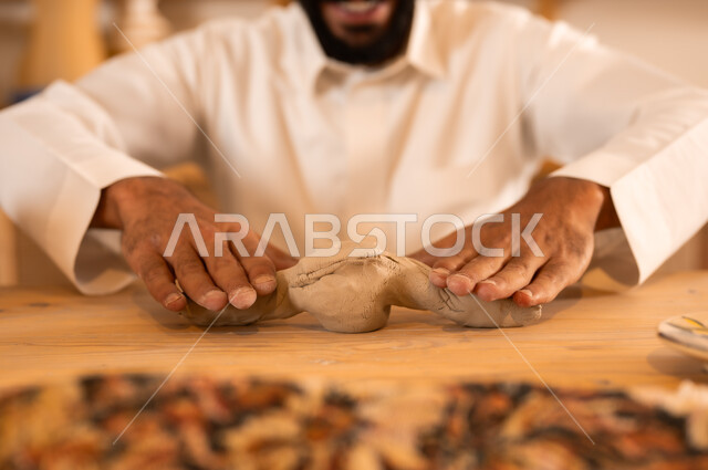 منحوتات وزخارف وأعمال فنية, ذكرى اليوم الوطني السعودي 23 سبتمبر, الصناعات التشكيلية اليدوية، شاب عربي خليجي سعودي يعمل بعجينة الفخار, حرف ومهن شعبية تراثية قديمة، تأسيس الدولة السعودية 1727 م, مناسبات واعياد وطنية