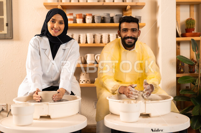 محترفون عرب سعوديون خليجيون يعملون في ورشة الاعمال الفنية، ممارسة مهارة صنع الفخار، احتراف تلوين الخزف والفخاريات، أعمال يدوية سعودية