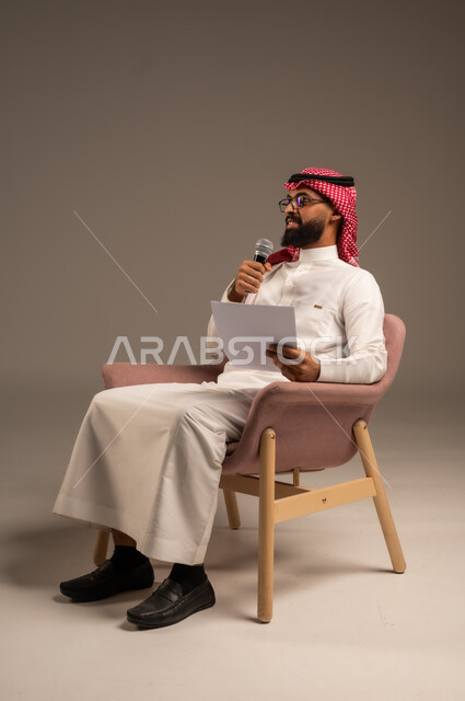 القيام بالحوارات والنقاشات، إعداد وتحضير أفكار الخطاب بشكل مسبق، بورتريه لرجل عربي خليجي سعودي يرتدي الثوب التقليدي والشماغ يجلس على الكرسي يحمل بيده مجموعة من الأوراق ومكبر الصوت يقوم بإلقاء الخطابات، قراءة الملاحظات والمعلومات، خلفية رمادية