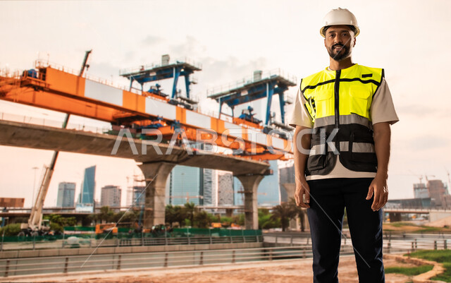Construction of foundations and structures for residential projects, construction, contracting and real estate development works in Saudi Arabia, Saudi Arabian Gulf Arab architect wearing helmet and safety vest standing on construction site, construction of buildings and mega projects