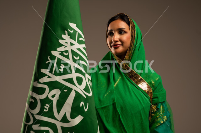 المشاركة بالأعياد الوطنية، اليوم الوطني السعودي، بورتريه لامرأة عربية خليجية سعودية محجبة  ترتدي الشيلة والبشت وترفع علم السعودية بايماءات الفخر والاعتزاز بالوطن، يوم العلم السعودي 11 مارس، العيد الوطني 23 سبتمبر، خلفية بيج
