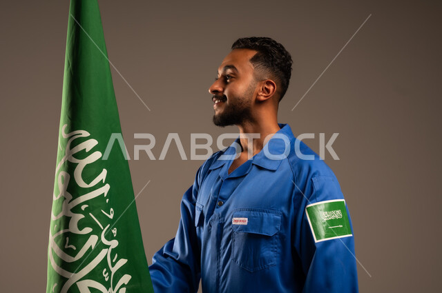 يوم العلم السعودي ١١ مارس، الاحتفال باليوم الوطني ٢٣ سبتمبر، بورتريه لرائد فضاء عربي خليجي سعودي يرتدي بدلة الفضاء السعودية يحمل بيده علم المملكة العربية السعودية,  خلفية بيج