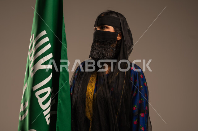 The Day We Began 1727 AD, the anniversary of the founding of the first Saudi state, February 22, Saudi National Day, a portrait of a Saudi Gulf Arab woman wearing the Central Region costume and holding the founding flag in her hand, pride in the country and belonging to it, beige background