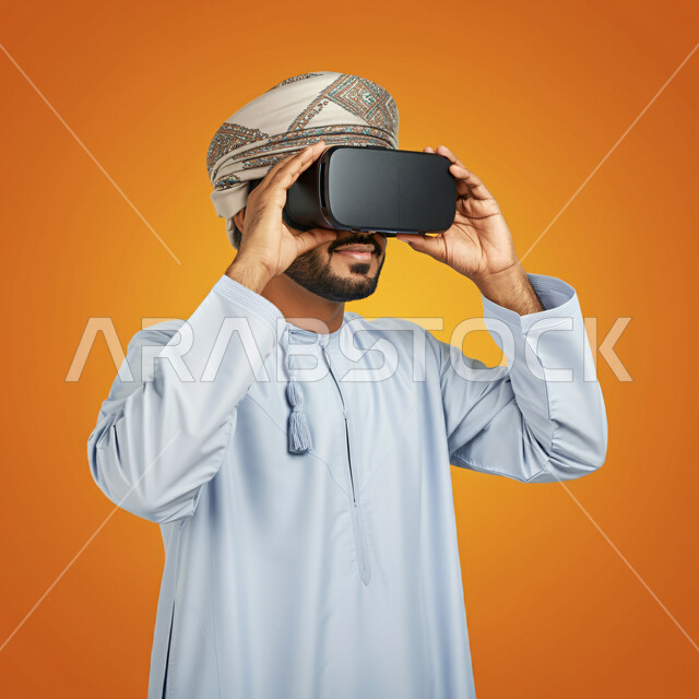 Technical and technological development, fun and entertainment by watching through virtual reality glasses, close-up portrait of a young Gulf Arab Omani man wearing a dishdasha and turban looking through 3D glasses and holding them in his hand, integration and simulation of the imaginary world, orange background