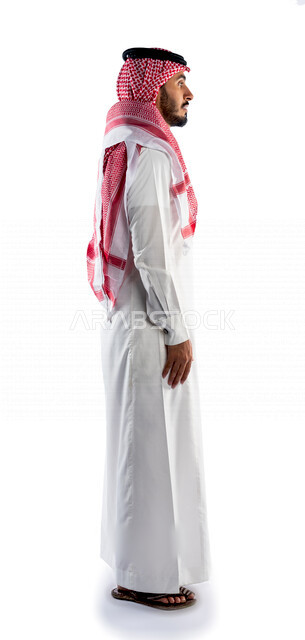 بورتريه لرجل عربي سعودي خليجي يقوم بجلسة تصوير بإيماءات وجه ويدين مختلفة ، منظر جانبي لرجل سعودي مسلم يرتدي زي تقليدي سعودي مع شماغ وعقال ، خلفية بيضاء
