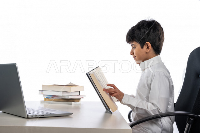 بورتريه لتلميذ عربي خليجي سعودي يرتدي الثوب السعودي التقليدي و سماعة الرأس ، يدرس من خلال منصة تعليمية للتعلم عن بعد ، ايماءات و تعابير للوجه و اليدين مختلفة ، تأدية الواجبات المدرسية ، التعلم عن بعد ، مفهوم التعليم عبر الانترنت