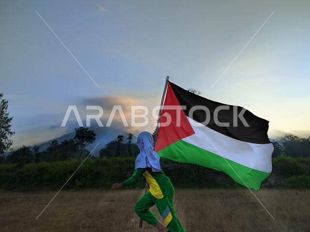 ذكرى احتفال اليوم الوطني الفلسطيني15نوفمبر، يوم بدينا1988م، حب الوطن والانتماء إليه، ولد عربي فلسطيني يرفع بيده علم الدولة الفلسطينية، المشاركة بالاعياد والمناسبات الوطنية، الركوض في احدى مناطق البلد